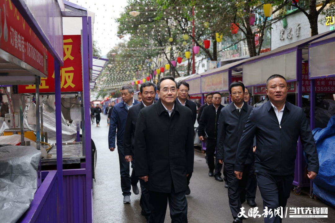 圖為徐麟在盤州市亦資街道三峽北路小吃一條街，察看店面攤點(diǎn)管理情況。.jpg